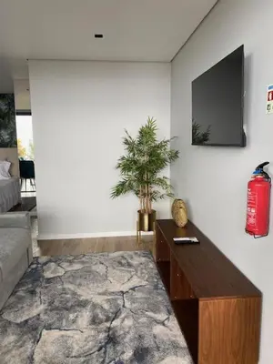 a living room with a couch and a tv on a wall at Atlântico Azul in Funchal
