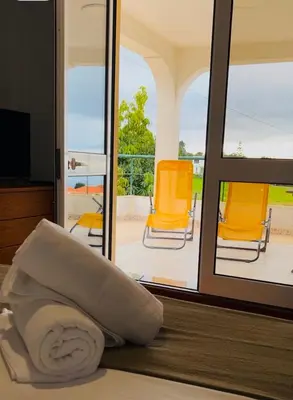 a pillow sitting on a bed next to a sliding glass door at Noite´s House - Prazeres in Prazeres