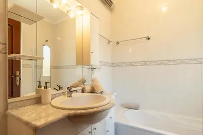 a bathroom with a sink and a tub and a mirror at Noite´s House - Prazeres in Prazeres