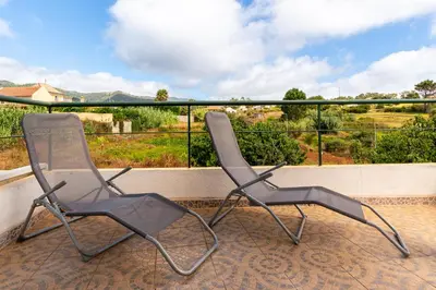 two chairs sitting on top of a balcony at Noite´s House - Prazeres in Prazeres