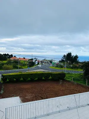 a view of a road with the ocean in the background at Noite´s House - Prazeres in Prazeres