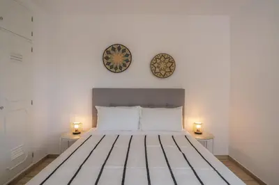 a bedroom with a bed with two lamps on the wall at Peaceful Ocean View Villa in Luz