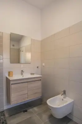 a bathroom with a sink and a toilet and a mirror at Peaceful Ocean View Villa in Luz