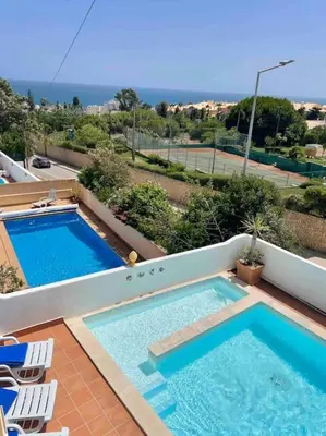 a view of two swimming pools on a balcony at Peaceful Ocean View Villa in Luz