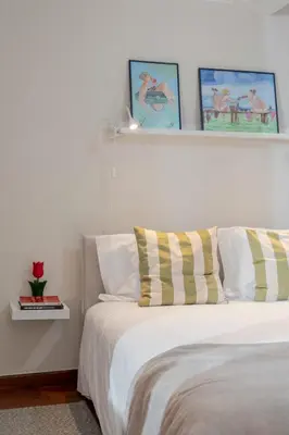 a bedroom with a bed with two pictures on the wall at Casa Frangipani by An Island Apart in Santa Cruz