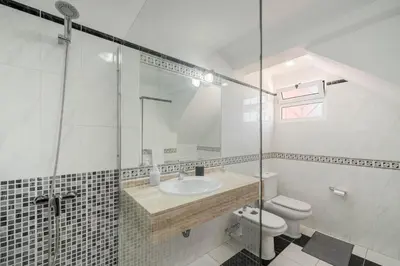 a bathroom with a sink and a toilet and a shower at Casa Frangipani by An Island Apart in Santa Cruz