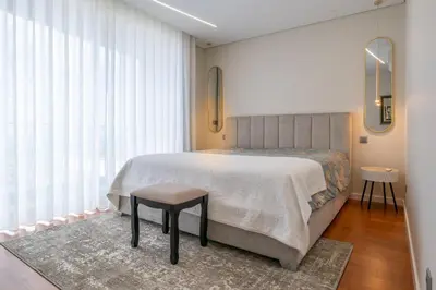 a bedroom with a bed and a stool in front of a window at Tiz house in Funchal