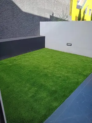 a yard with green grass next to a building at Tiz house in Funchal