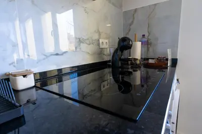 a glass counter top in a room with a glass table at Sun Hill Apartment in Santa Cruz