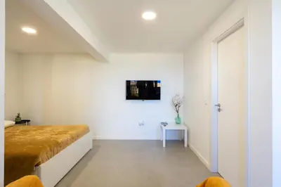 a bedroom with white walls and a large bed at Sun Hill Apartment in Santa Cruz