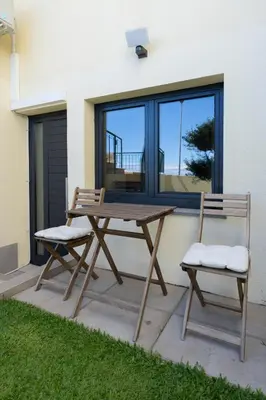 a picnic table and two chairs on a patio at Sun Hill Apartment in Santa Cruz
