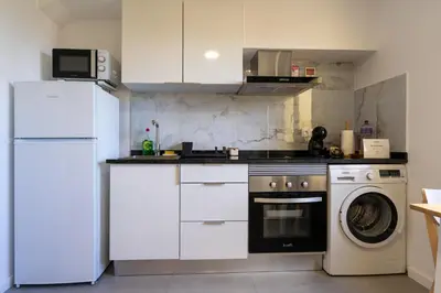 a kitchen with a refrigerator and a washing machine at Sun Hill Apartment in Santa Cruz