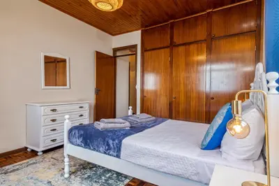 a bedroom with a bed and a wooden wall at De Freitas Home by Rent-a-key in Porto Moniz