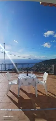 a white table with wine glasses on top of a roof at ARTIST HOUSE Rooms With View And Shared Kitchen in Arco da Calheta