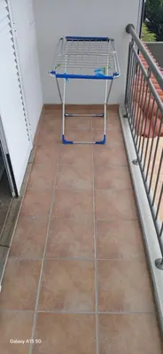 a balcony with a table on a tiled floor at ARTIST HOUSE Rooms With View And Shared Kitchen in Arco da Calheta