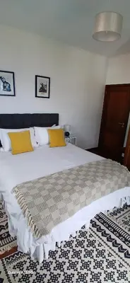 a bedroom with a large white bed with yellow pillows at ARTIST HOUSE Rooms With View And Shared Kitchen in Arco da Calheta