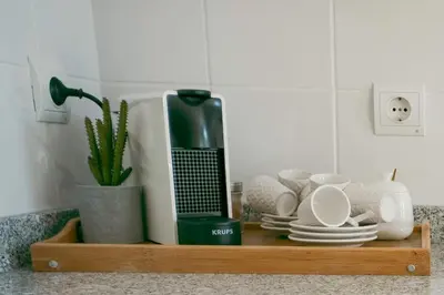 a shelf with cups and plates and a blender at Kora Home in Santa Cruz