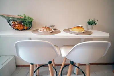 a table with two white chairs and two plates of food at Kora Home in Santa Cruz