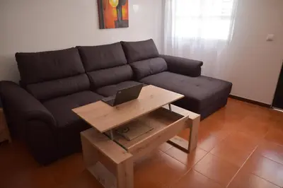 a living room with a couch and a table with a laptop at Rita's house in Ponta Delgada