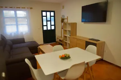 a living room with a table and a couch at Rita's house in Ponta Delgada