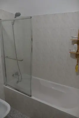 a shower with a glass door in a bathroom at Rita's house in Ponta Delgada