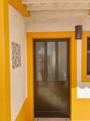 a black door in a room with yellow walls at Ocean Breeze & Sea Salt Apartment in Luz