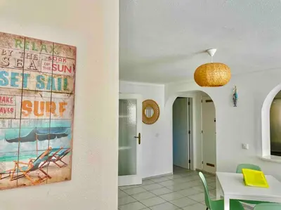 a dining room with a table and a painting on the wall at Ocean Breeze & Sea Salt Apartment in Luz