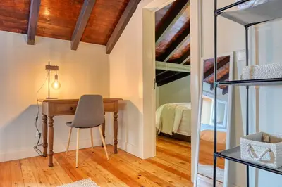 a home office with a desk and a bed at Chalet da Nogueira, a Home in Madeira in Ponta do Sol
