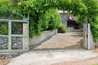 an entrance to a garden with a green gate at Chalet da Nogueira, a Home in Madeira in Ponta do Sol