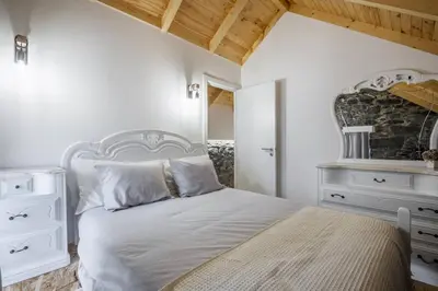 a bedroom with a white bed and a mirror at Mountain Retreat by Homie in Porto Moniz