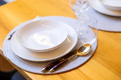 a white plate and spoon on a table with glasses at Casa Da Avó Clementina Nº 30 in Funchal