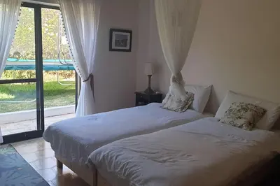 a bedroom with two beds and a large window at Casa KIWI 3 chambres et piscine in Luz