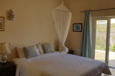 a bedroom with a large white bed with a window at Casa KIWI 3 chambres et piscine in Luz