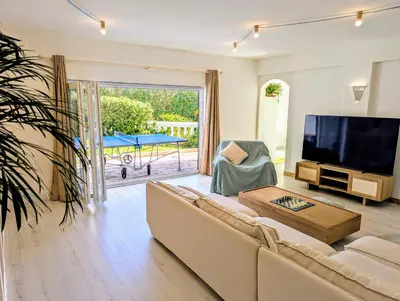 a living room with a couch and a flat screen tv at Casa KIWI 3 chambres et piscine in Luz