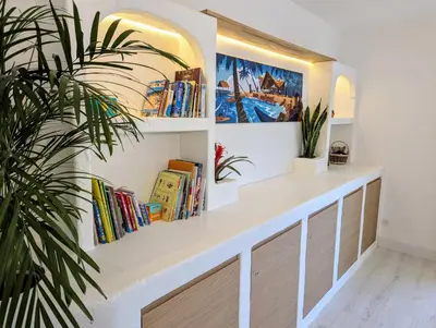 a room with a book shelf with books at Casa KIWI 3 chambres et piscine in Luz