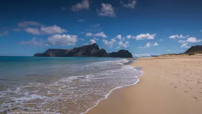 a sandy beach with mountains in the background at Casa Yucca - Porto Santo Island in Porto Santo