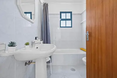 a white bathroom with a sink and a bath tub at Casa Yucca - Porto Santo Island in Porto Santo