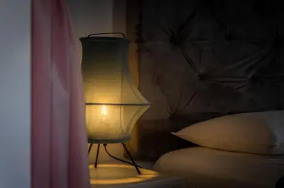 a lamp sitting in a bedroom next to a bed at Panoramic House in Ribeira Brava