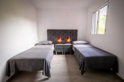 a room with two beds and a desk with two lamps at Panoramic House in Ribeira Brava