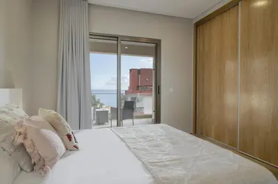 a bedroom with a large bed and a large window at Casa das Raposinhas I in Funchal