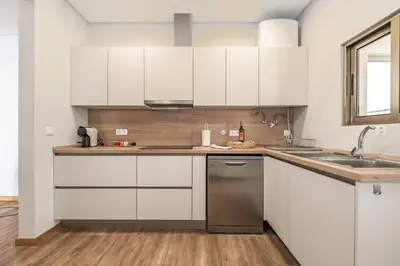 a kitchen with white cabinets and a sink at Casa das Raposinhas I in Funchal