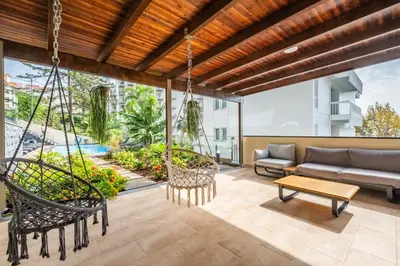 a patio with a swing and a couch at Casa das Raposinhas I in Funchal