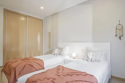 two beds in a room with white walls at Casa das Raposinhas II in Funchal
