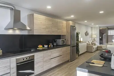 a kitchen with wooden cabinets and a stove top oven at Casa das Raposinhas II in Funchal