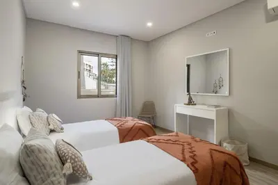 a bedroom with two beds and a couch at Casa das Raposinhas II in Funchal