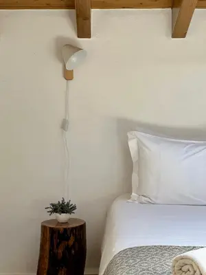 a bedroom with a bed and a lamp on a table at Pure Flor de Esteva in Vila do Bispo