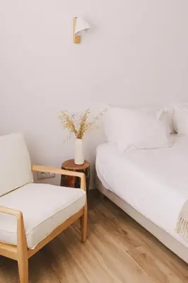 a bedroom with two beds and a chair at Pure Flor de Esteva in Vila do Bispo