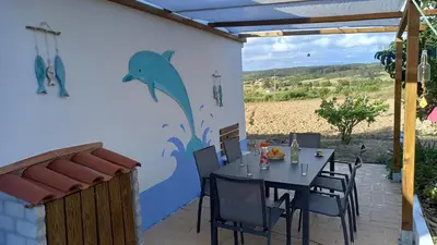 a patio with a table with a dolphin painted on the wall at Charme Rústico in Aljezur