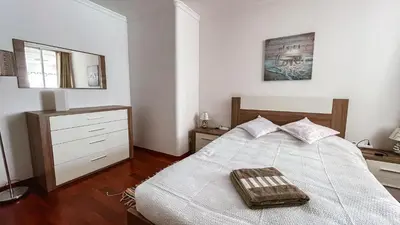 a bedroom with a bed and a dresser and a mirror at Reis Magos Beach Caniço Sea line Apartment in Caniço