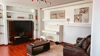 a living room with a television and a piano at Reis Magos Beach Caniço Sea line Apartment in Caniço
